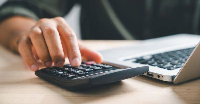 Close up of a man using a calculator